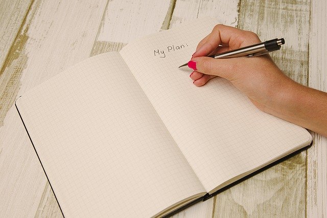 A woman’s hand writing a plan.